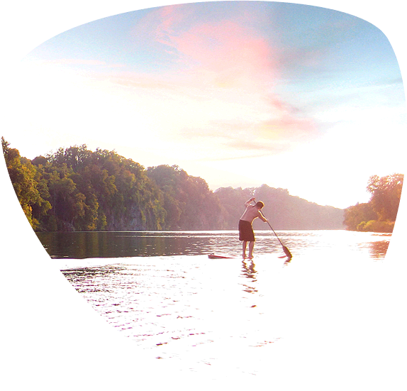 Male and female riding stand up paddle boards (SUP) on Douglas Lake.